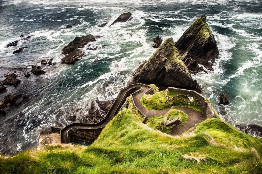 Dunquin Harbor Ireland - dramatic coastal cliffs and winding stone pathway to Wild Atlantic Way pier.